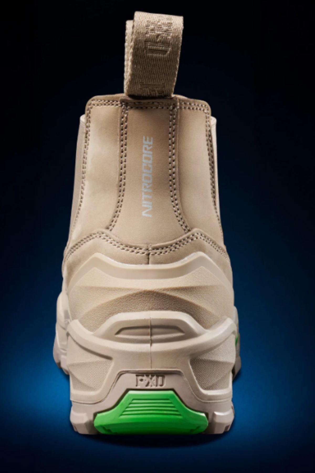 The FXD DURA X-3 Slip On Work Boots, shown from the back, feature a thick NITROCORE sole system with green accents, a heel pull tab, and "NITROCORE" printed vertically against a dark blue gradient background.