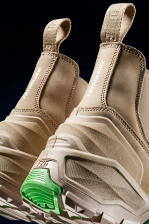 Close-up of the FXD DURA X-3 Slip On Work Boots’ heels, highlighting thick, textured soles with a green accent and "NITRO OUTSOLE" text—combining sporty style with comfort inspired by durable industrial work boots.
