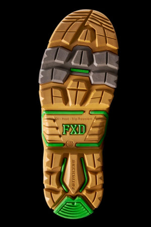 Close-up of FXD DURA X-3 Slip On Work Boots' puncture-resistant sole featuring yellow, gray, and green tread with "FXD" and "NITROCORE" labels. Text notes oil, heat, and slip resistance. Black background highlights advanced NITROCORE sole system.