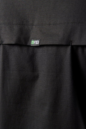 Close-up of a black stretch fabric with a stitched seam and small white and green "FXD" label, from the FXD LSH-3 Vented Work Shirt.