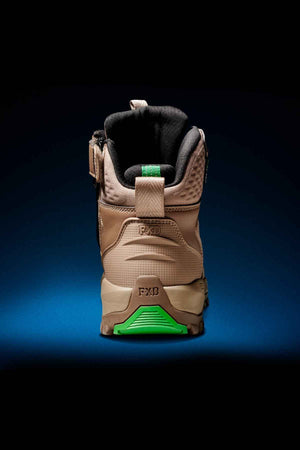 The FXD WB-6 Work Boot, displayed from the back against a dark blue background, boasts a tan and black design. It features a reinforced heel with a green accent at the sole, padded ankle support, and a PORON heel insert. The brand name "FXD" is imprinted on both the heel and the heel loop, ensuring it meets top safety standards.