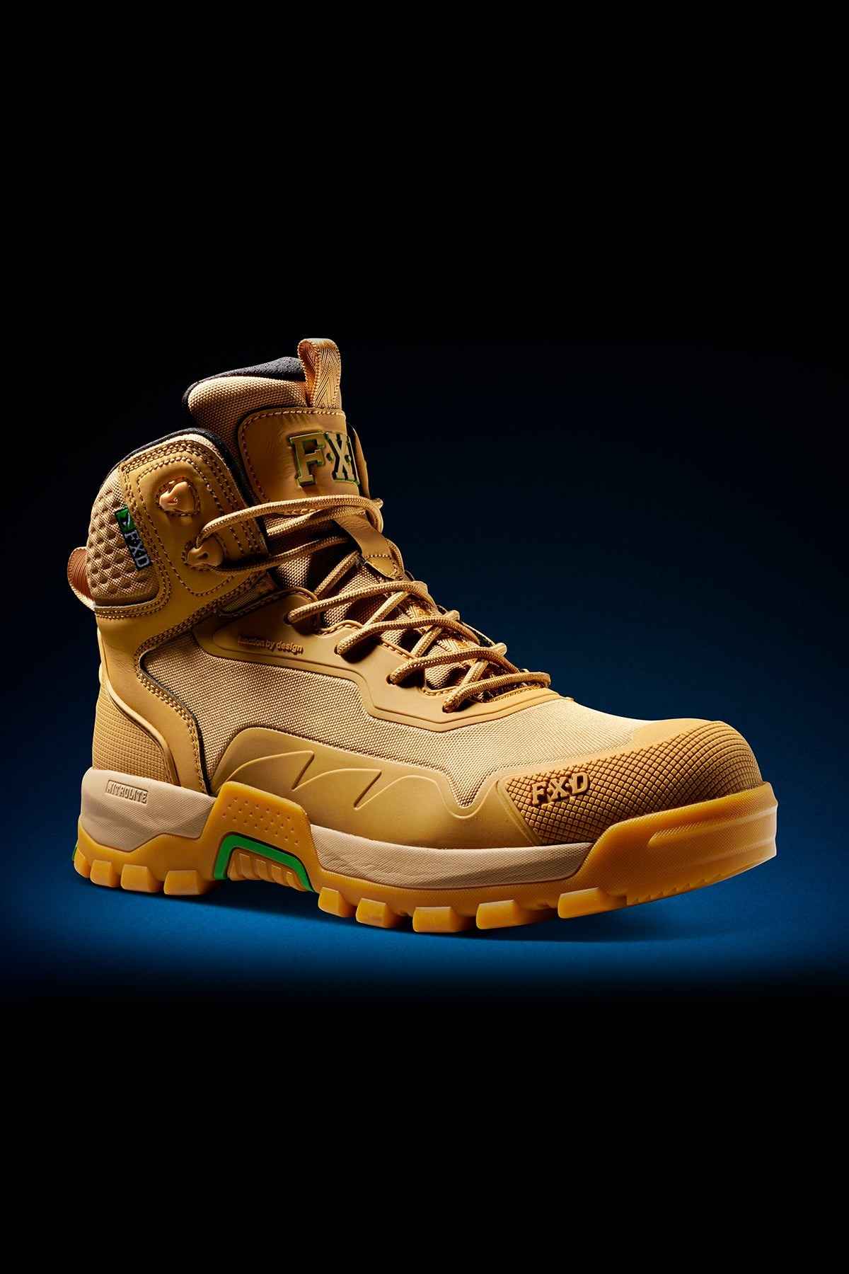 A tan FXD WB-6 Work Boot stands out against a dark background, showcasing its sturdy laces, thick rugged sole, and reinforced toe and heel areas. The detailed stitching and logo are prominently visible, complemented by green accents around the synthetic upper and a Poron heel insert for enhanced comfort.