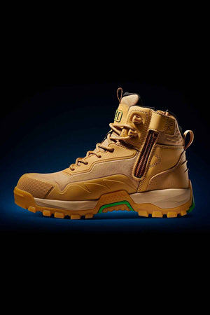 The FXD WB-6 Work Boot is a high-top hiking boot made from tan leather, featuring a thick, rugged sole and green accents. It includes a side zipper, a strap with a buckle, detailed stitching, and a Poron heel insert for added comfort. The boot is displayed on a dark gradient background.