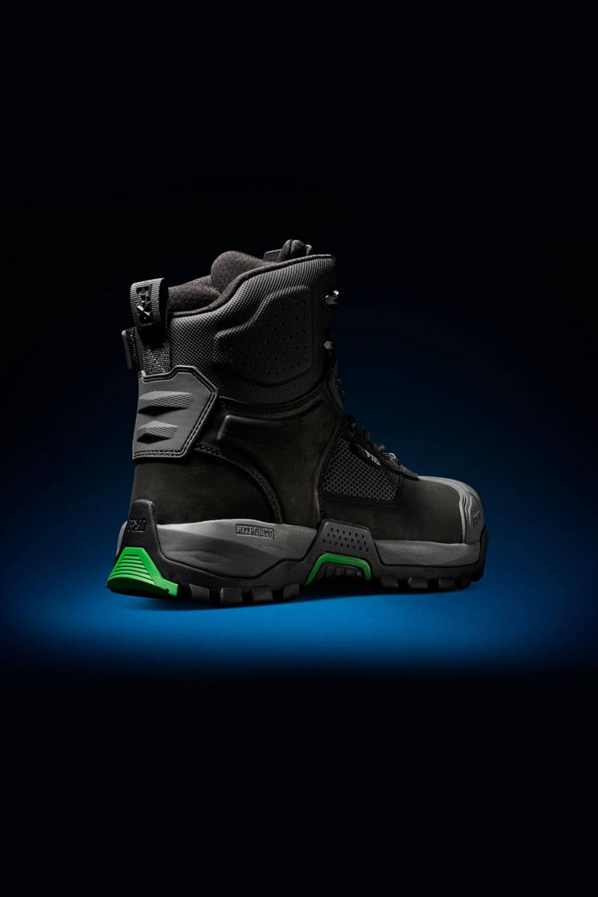 A single FXD WB-1 Work Boot in black and green, featuring a sturdy, slip-resistant sole, is displayed against a dark background with blue lighting at the base. The boot offers protective ankle support, reinforced areas for enhanced durability, and a safety toe for added protection.