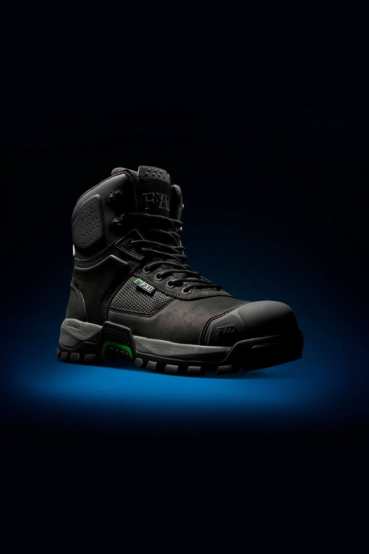 Against a dark background with a subtle blue glow beneath it, the FXD WB-1 Work Boot is showcased, featuring black color with thick tread, green accents, and high ankle support. This durable boot is designed for rugged use and comes equipped with slip-resistant soles.