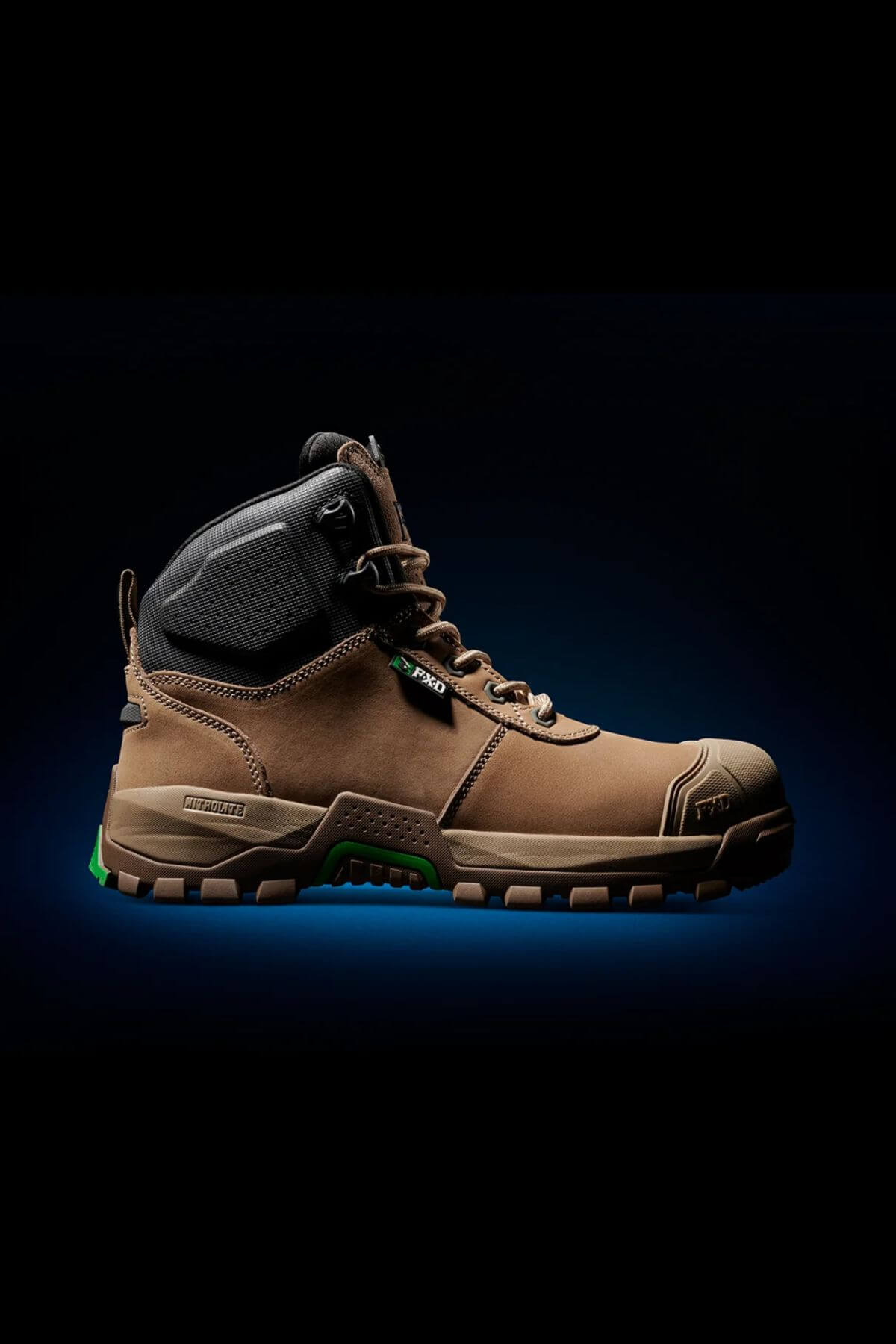 A single FXD WB-2 Work Boot, featuring a brown exterior with green accents and a black padded collar, showcased sideways against a dark backdrop. The boot's rugged tread, lace-up design, and safety toe emphasize its slip-resistant durability and robust construction.