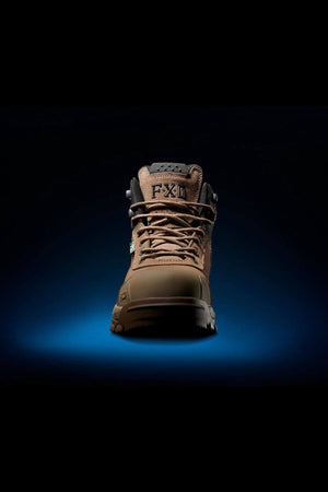 The FXD WB-2 Work Boot is showcased against a black background illuminated by a blue spotlight beneath it. The single brown boot, characterized by its thick laces and robust construction, displays the letters "F" and "X1" on the tongue. It features slip-resistant soles and a safety toe for enhanced protection.