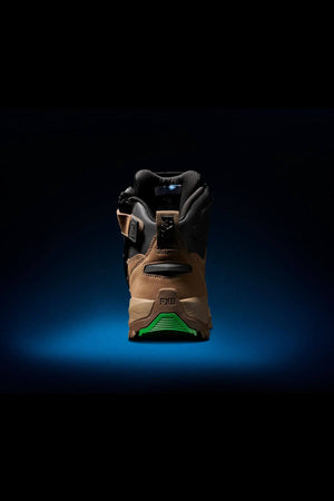 A single `FXD WB-2 Work Boot` is displayed from the back, centered against a dark background. The neon green sole with the "FXD" logo visible on the heel stands out. The well-lit boot emphasizes its rugged design, slip-resistant texture, and safety toe features.