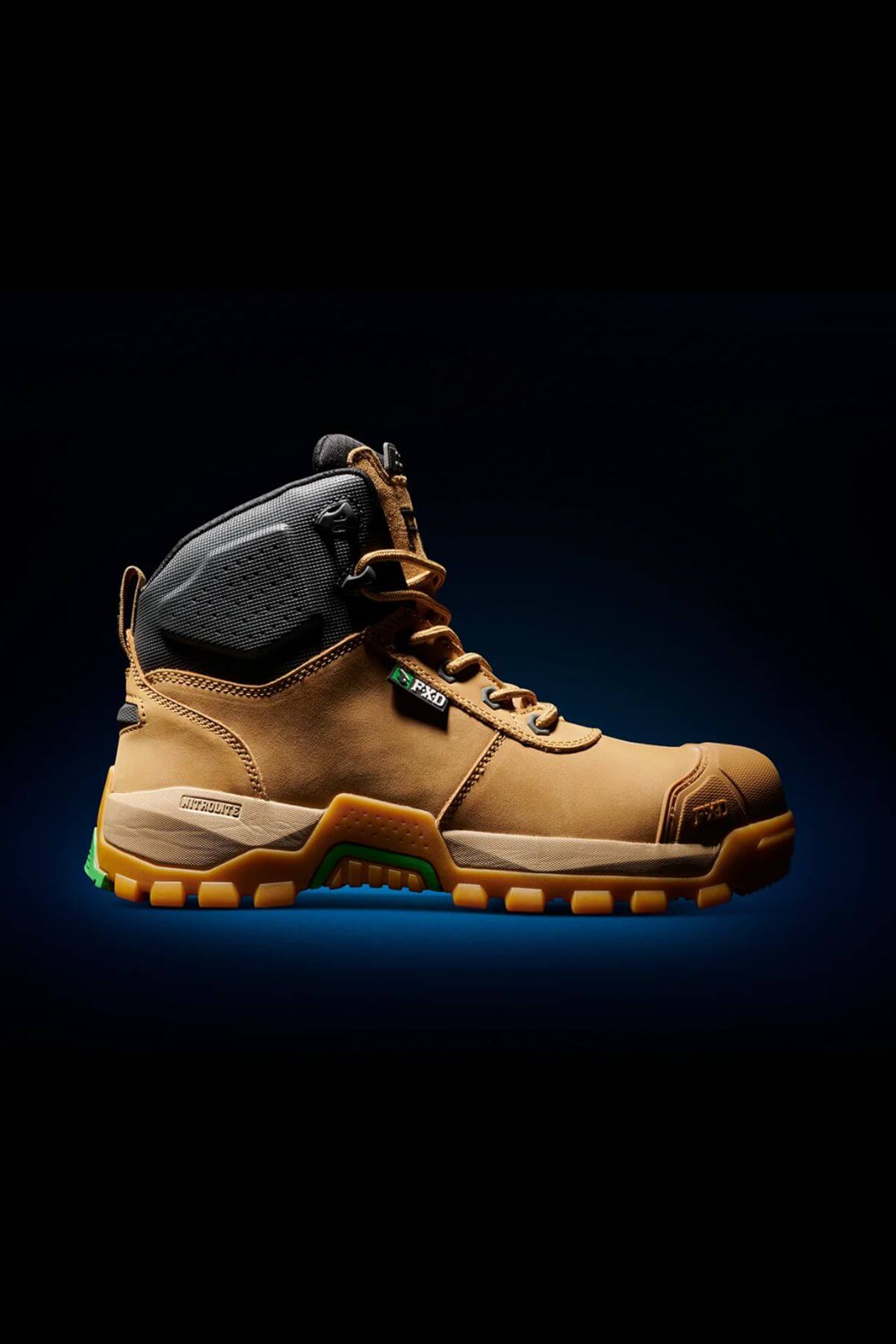 The FXD WB-2 Work Boot, featuring a rugged brown and black design with sturdy, slip-resistant soles, is showcased against a black background accented by a subtle blue glow. The boot includes black ankle padding, metal eyelets for laces, and a reinforced safety toe area.