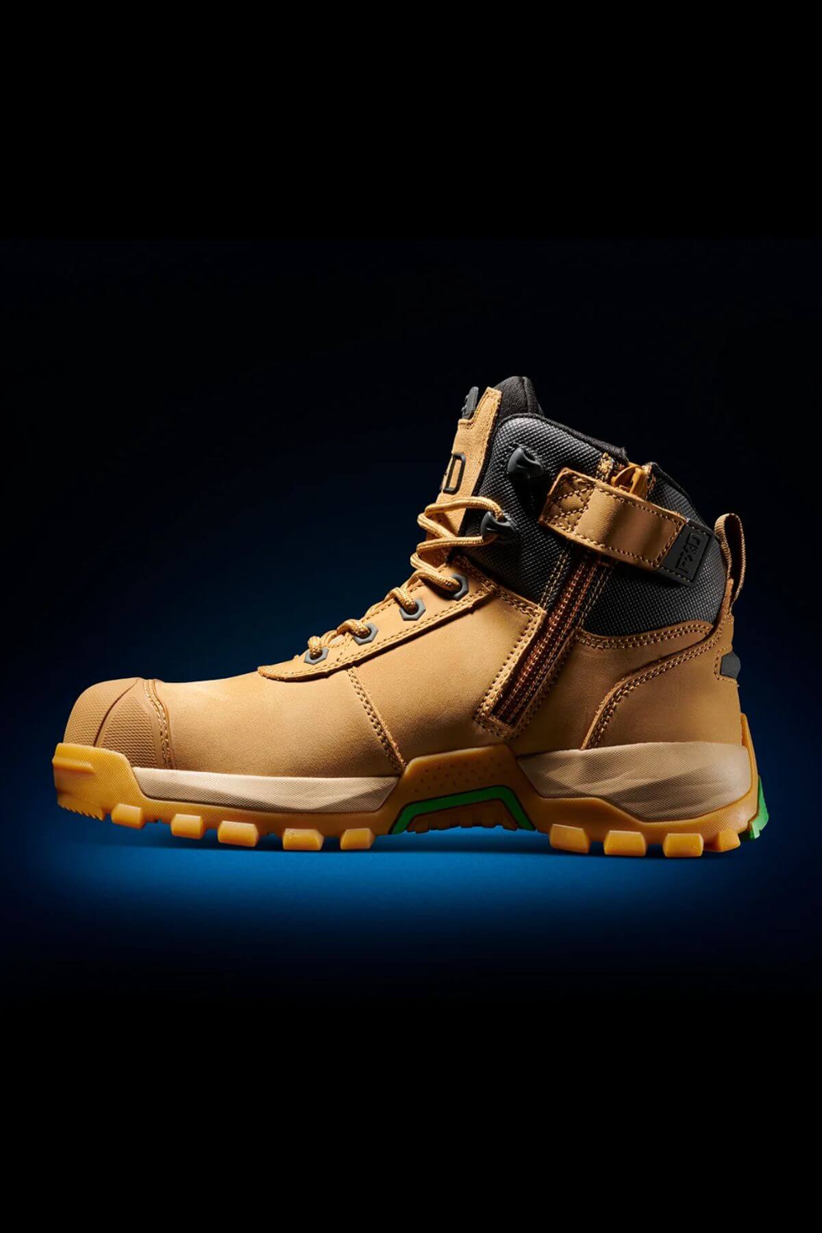 An FXD WB-2 Work Boot in brown, featuring rugged soles and a black ankle strap, is showcased against a dark background with a hint of blue glow beneath it. The boot highlights intricate stitching, a side zipper, and a slip-resistant safety toe design perfect for heavy-duty tasks.