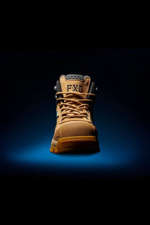 A single FXD WB-2 Work Boot in tan is brilliantly showcased against a dark backdrop, highlighting its rugged design, sturdy laces, and distinct "FXD" branding on the tongue. The boot’s safety toe and reinforced sole emphasize its durability and suitability for heavy-duty tasks, while the slip-resistant tread ensures reliable traction across diverse conditions.