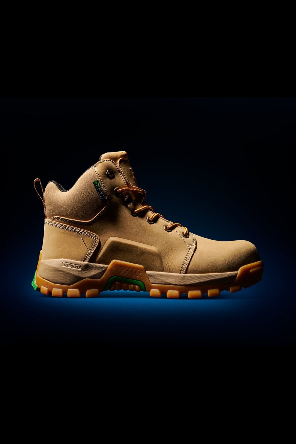 The FXD WB-3 Work Boot is a tan, high-top crafted from premium leather, featuring a rugged sole, side branding, brown laces, and safety toe design for job protection. It's set against a black background with a subtle blue gradient.
