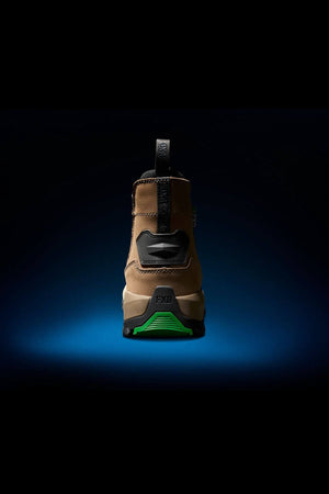 This image displays the back view of an FXD WB-4 Work Boot in tan and black, featuring green accents. It's set against a dark background with a subtle blue highlight. The boot looks robust and slip-resistant, suggesting its suitability for outdoor or work environments.