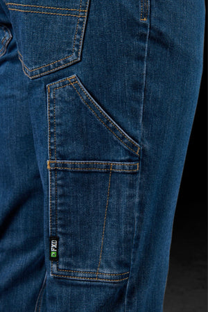 Close-up of the side pocket and stitching details on FXD WD-4 blue denim jeans, made from COOLMAX EcoMade fabric, featuring a small green and black "FXD" label by the pocket seam.