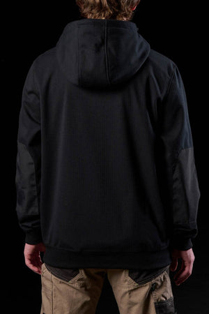 A person faces away from the camera, wearing a black FXD WF-3 Jacket and beige cargo pants against a black background.