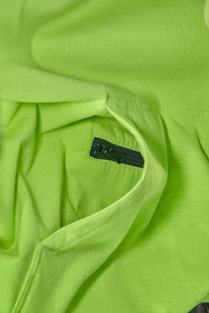Close-up of the FXD WF-1 Hoodie's neon green fabric with a black zipper partially unzipped, revealing a pocket. The texture of the fabric is smooth, making it ideal for a water-resistant hoodie.