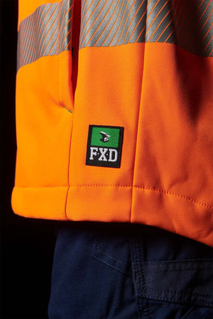 Close-up of an individual wearing an FXD WO-3T Hi Vis Soft Shell Work Jacket made from breathable wind and water-resistant 3-layer polyester softshell in orange and gray. The bottom of the jacket is visible, along with part of the person's dark blue pants. The background is black.