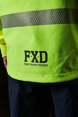 Close-up of a person wearing a neon yellow FXD WO-3T Hi Vis Soft Shell Work Jacket with horizontal reflective stripes. The "FXD" logo and "Function by Design" are printed on it. This wind and water-resistant garment pairs perfectly with dark pants for excellent UPF protection.
