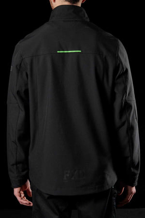 A person wears the FXD WO-3 Soft Shell Work Jacket, featuring a green horizontal stripe on the upper back. This breathable wind and water-resistant jacket offers 50+ UPF protection, visible seams, and a subtle "FXD" print near the bottom, standing out against its solid black background.