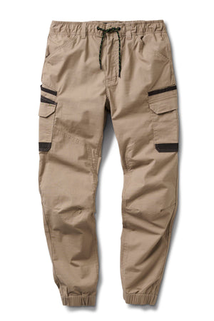 The FXD WP-12C are tan cargo jogger pants featuring black zipper utility pockets, an elastic drawstring waistband, and elastic ankle cuffs.