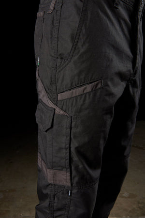 Close-up of a person's lower body wearing black FXD WP-5 pants. The pants feature modern utility pockets and reinforced stitching. The advanced stretch fabric and the dark background emphasize the details and texture of the FXD WP-5 cargo pants.