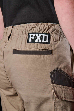 Close-up of a person wearing the FXD WS-7 Work Short in tan, showcasing the black "FXD" logo on the waistband. These shorts are designed with a back pocket, reinforced stitching, and offer utility while maintaining comfort.