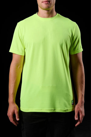 A person wears the FXD WT-4 Hi Vis Tech Teeβa short-sleeve neon yellow-green, quick-drying, moisture-wicking shirt with a small green and black tag at the bottom hemβstanding against a black background, face not fully visible.