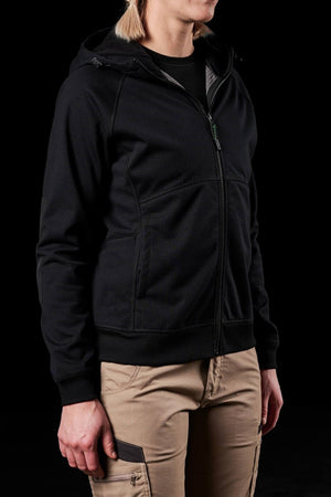 A person in a sleek black zip-up hoodie and khaki cargo pants stands against a dark background. Their hands rest casually at their sides, capturing the effortless style of the FXD Womens WF-3W Jacket with its discreet water-resistant feature.
