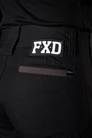 Close-up of a person wearing FXD Womens WP-8W black lightweight stretch ripstop pants, with a visible FXD logo on the back pocket. The pants also feature a small label next to the pocket and 50+ UPF protection. The image focuses on the back part, showcasing the fabric, stitching details, and abrasion panels.