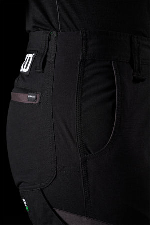 Close-up view of FXD Women's WP-8W black work pants showcasing details like a side pocket, belt loop, and a small tag labeled "Dura360." The fabric looks durable and is probably intended for heavy-duty use, as evidenced by the abrasion panels and material texture.