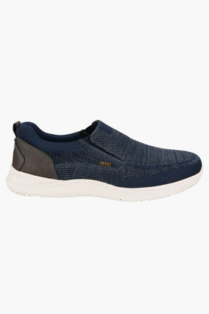 The Florsheim Conway Knit Moc Toe Slip On is a navy slip-on sneaker with a white sole, textured knit upper, small brown "1921" side label, grey heel accent, memory foam insole for comfort, and no visible laces.