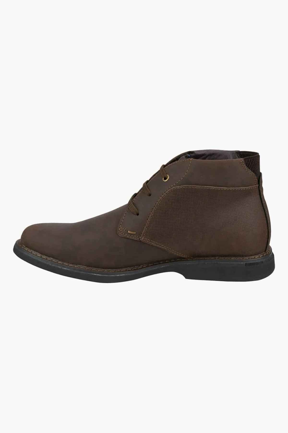 The Florsheim Otto Chukka Boot showcases a brown leather upper with three eyelets, a textured side panel, cushioned footbed, dark sole, and stitching details, elegantly presented in a side profile against a white background.