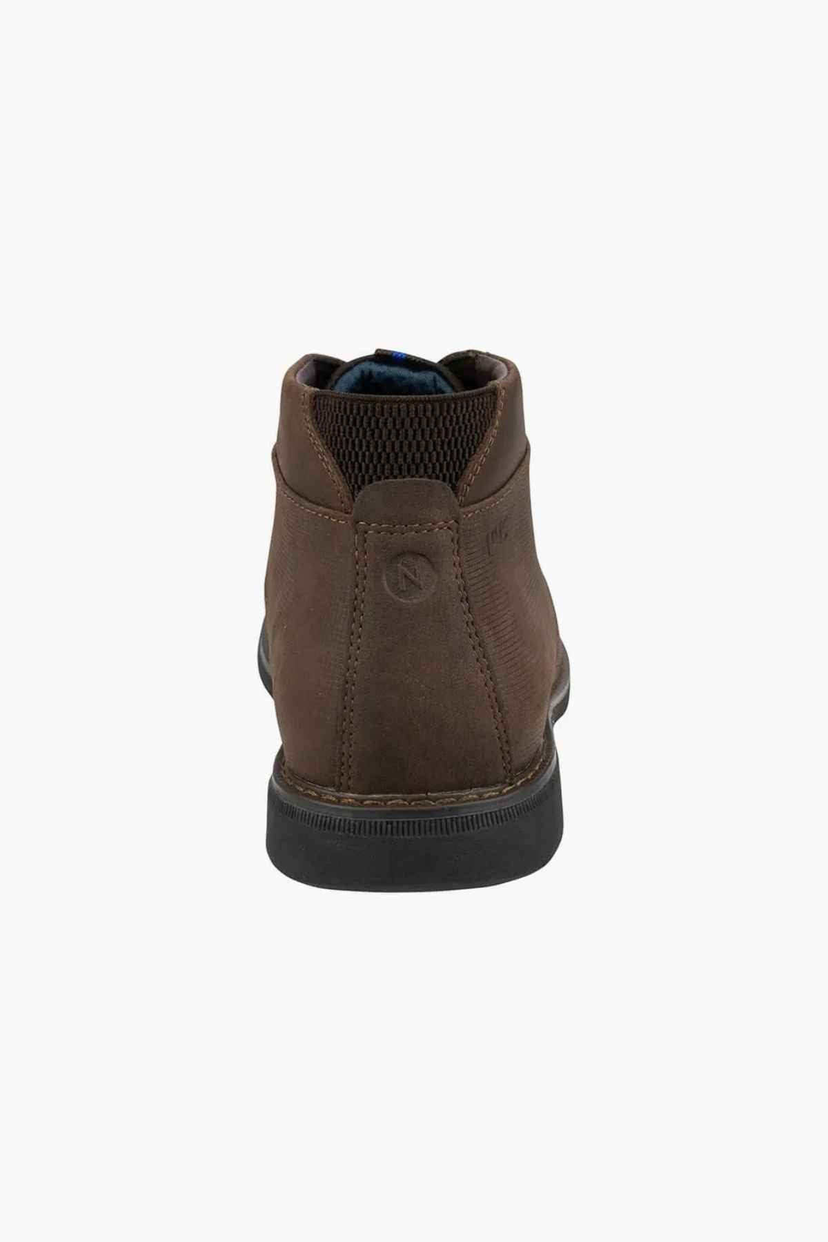 The Florsheim Otto Chukka Boot showcases a brown leather upper and black rubber sole. It features a subtle heel logo, intricate stitching details, and a textured collar for comfort, with a cushioned footbed for enhanced steps.
