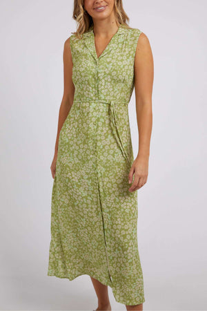 The Foxwood Anatayla Floral Dress, ideal for warm weather occasions, is worn by a person against a plain backdrop. The green sleeveless dress showcases a floral pattern with a V-neck and button-down design, all crafted from lightweight fabric.