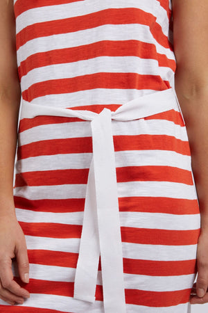 Model wears the Foxwood Bondi Stripe Dress with horizontal red and white stripes, a flattering cut, and a white waist tie. Only the torso and hands are visible.