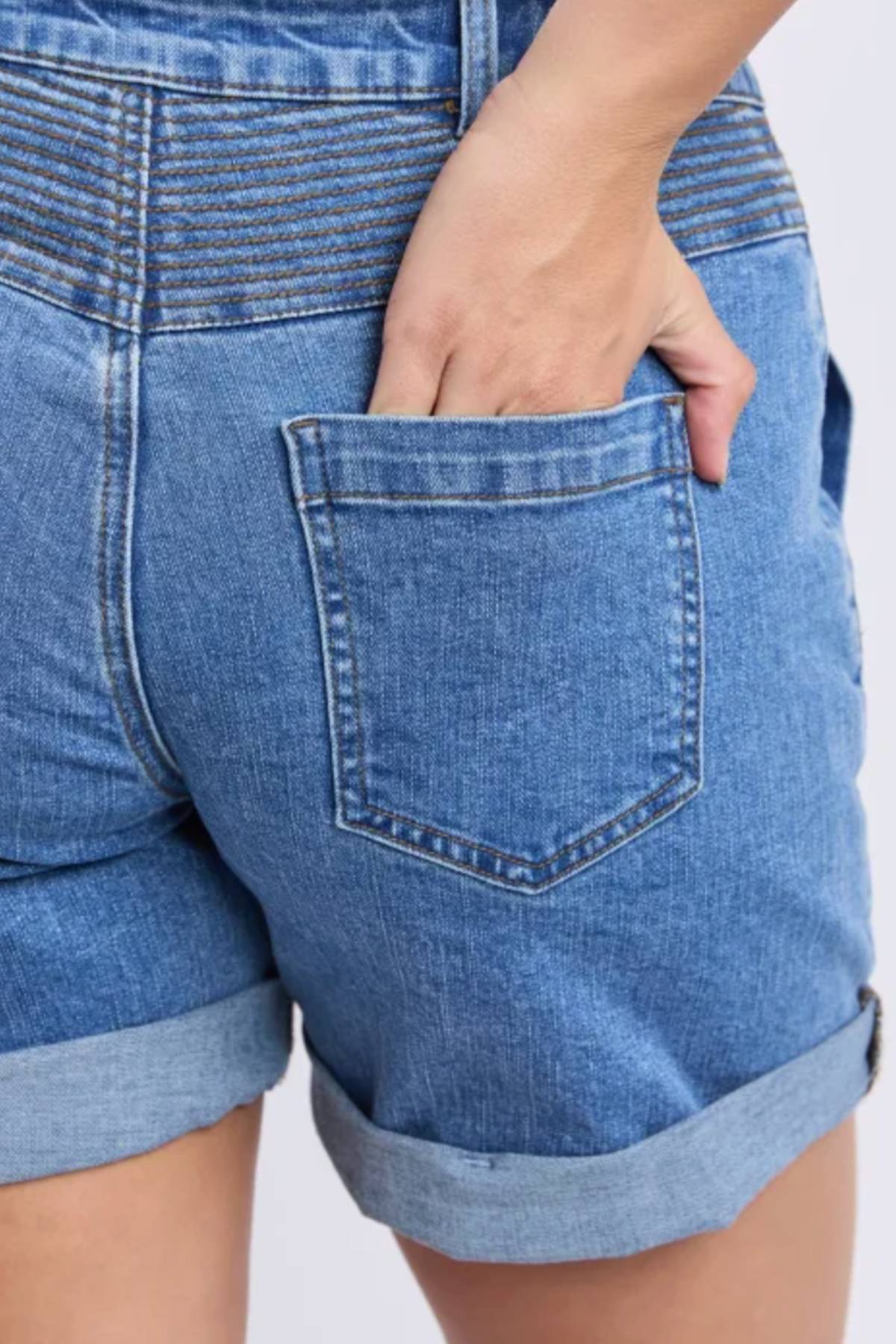 A person wears the Foxwood Devi Short with rolled cuffs, hand in the back pocket. The photo highlights stitching details and offers a close-up of the back view of these casual shorts.