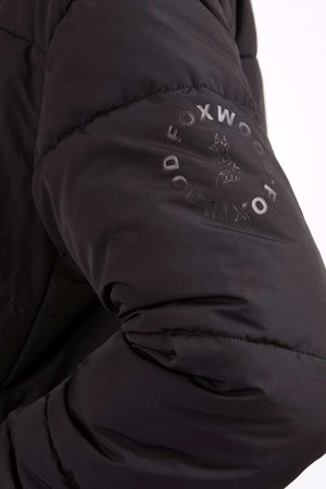 Close-up of the Foxwood Essential Puffer Jacket's black sleeve, showcasing "FOXWOOD" and a fox logo in a circular design—an elevated essential for your winter wardrobe.
