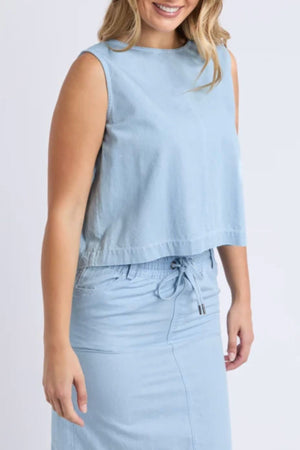 A woman in the Foxwood Zetta Top and a matching light blue drawstring skirt smiles with her hair downβan ideal summer look.