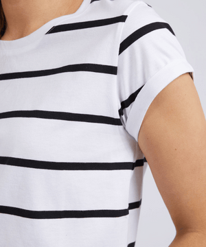 Someone wearing the Foxwood Manly Stripe Tee—a white short-sleeve shirt with black stripes—shows their upper torso, one shoulder, and part of their arm against a plain background, emphasizing the tee's comfortable fit.
