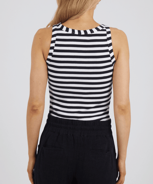 A person with long blonde hair is shown from the back, wearing the Foxwood Ruth Tank and black pants against a plain light background.