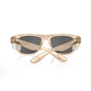 SafeStyle Fusions Champagne Frame Tinted Lens sunglasses shown from the back with crossed arms. The beige, translucent polycarbonate frames feature dark tinted lenses and display the SafeStyle branding near the hinges.