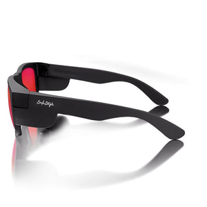 A pair of sleek SafeStyle Fusions sunglasses with a matte black frame, mirror red polarised lenses, displaying the brand "SafeStyle" on the side. Positioned on a reflective surface, these glasses showcase an elegant and modern design while offering UV protection.