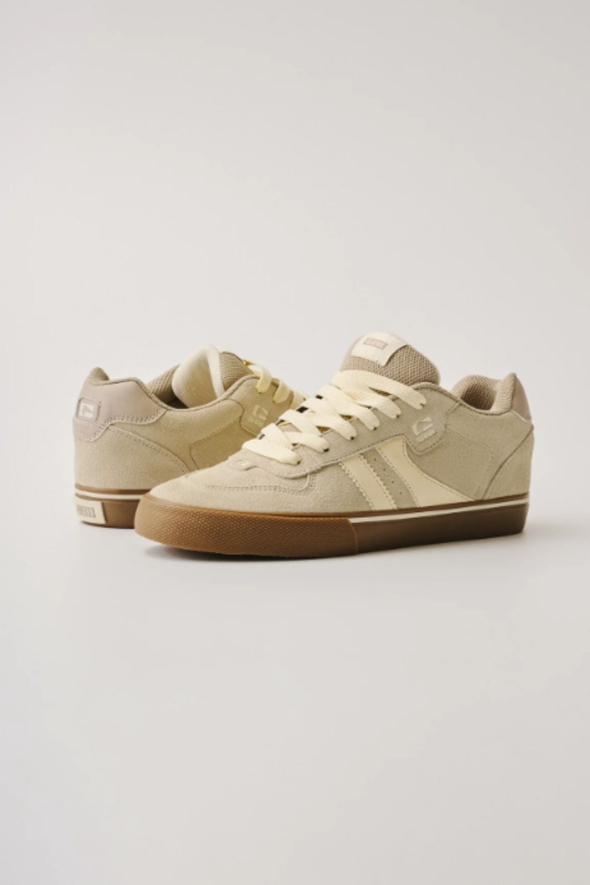 The Globe Encore-2 sneakers in beige and tan suede feature white laces, gum soles, and a cushioned insole for durability. Displayed on a plain white background, one shoe shows the front while the other displays the side and back.
