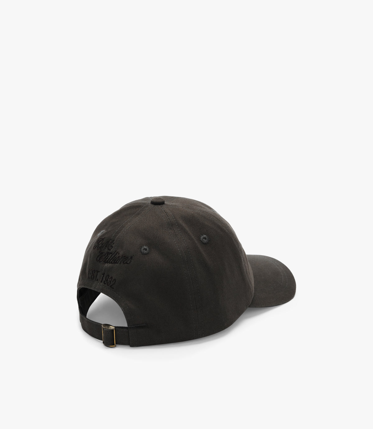 The RM Williams Longhorn Cap is a black cotton twill baseball cap displayed from the back, featuring an adjustable strap with a metal buckle and subtle embroidered text above the opening against a plain white background.