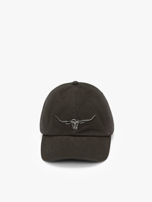 The RM Williams Longhorn Cap is a black cotton twill hat featuring an embroidered longhorn skull logo on the front, shown against a plain white background.