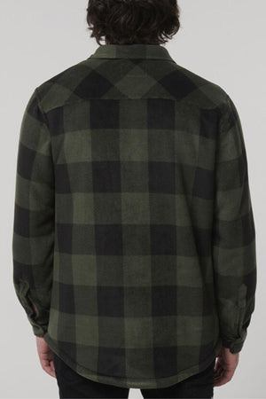 A person with medium-length dark hair is facing away from the camera, wearing a green and black checkered long-sleeve shirt that looks as cozy as a Hard Yakka Sherpa Bonded Fleece Jacket. The background is plain and light-colored.