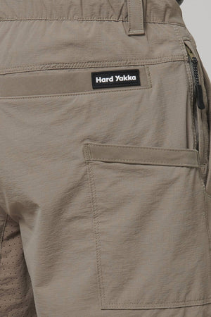 Close-up of Hard Yakka X Short Short in khaki with a rectangular label above the back pocket, made from durable Cordura Nylon. These shorts feature a right-side zippered pocket and 4-way stretch fabric for enhanced flexibility and active comfort.