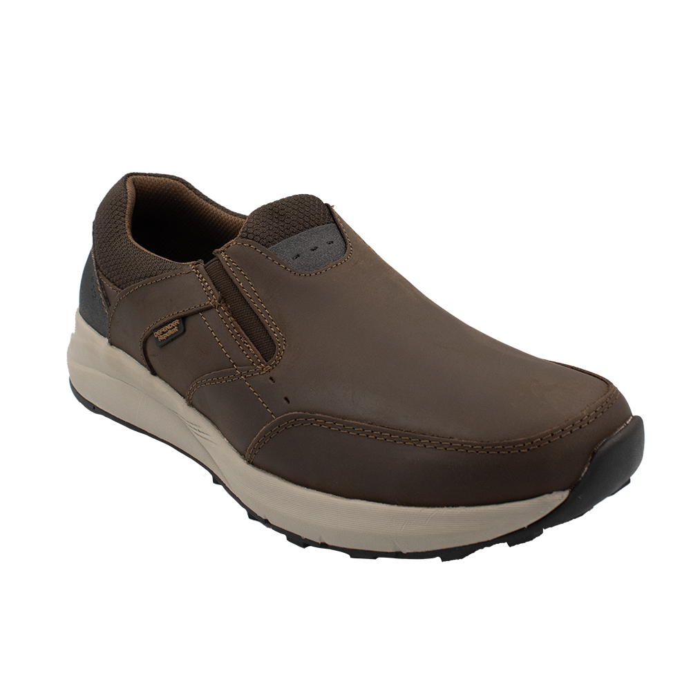 The Florsheim Excursion Slip On is a brown slip-on shoe with a white sole and black detailing. It offers shock absorption, visible stitching, and elastic side panels for comfort. Blending casual and sporty elements, it ensures superior moisture management for versatile style on various occasions.