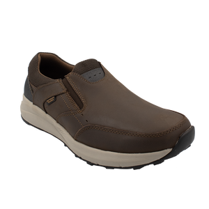 The Florsheim Excursion Slip On is a brown slip-on shoe with a white sole and black detailing. It offers shock absorption, visible stitching, and elastic side panels for comfort. Blending casual and sporty elements, it ensures superior moisture management for versatile style on various occasions.