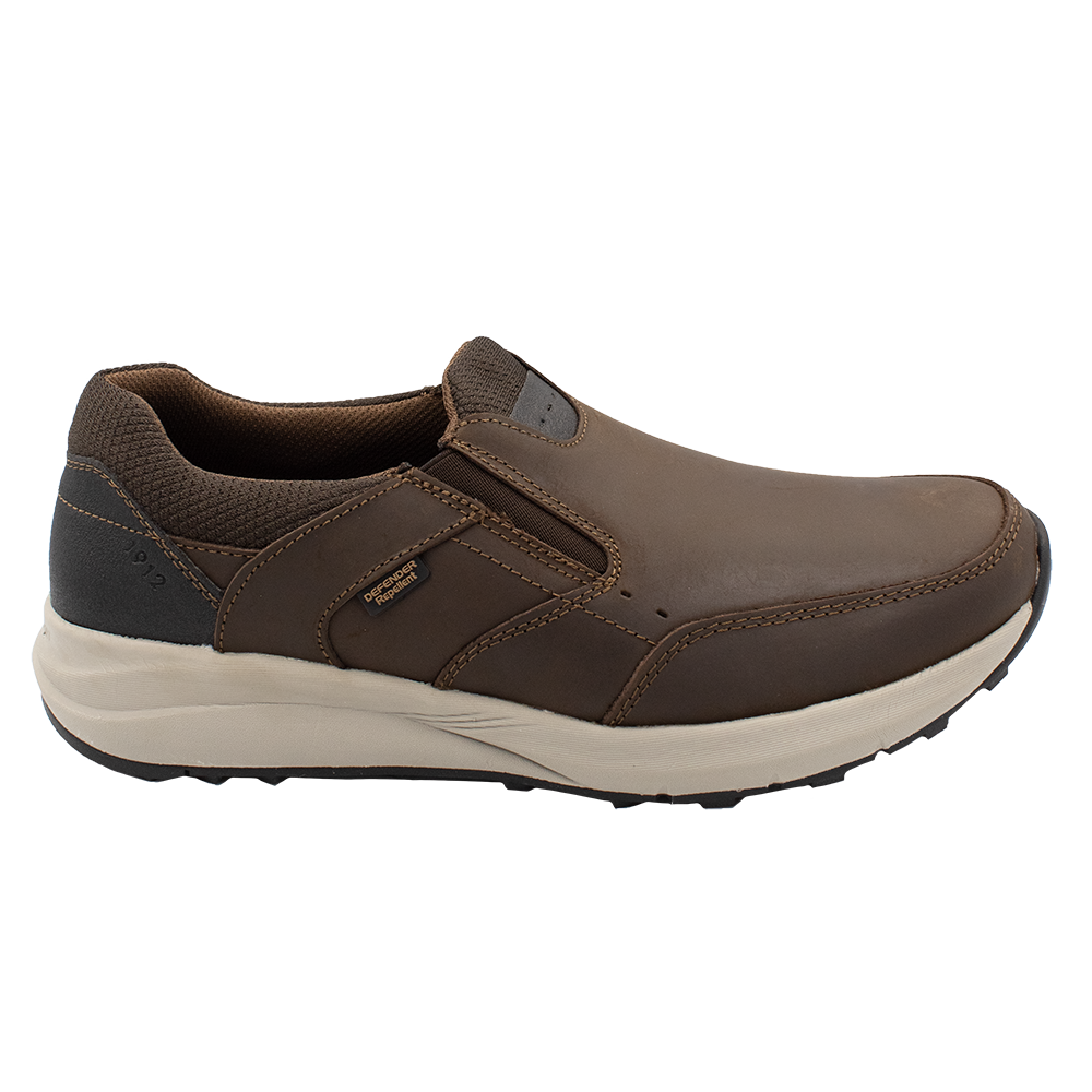 The Florsheim Excursion Slip On features a smooth brown leather upper, dark fabric around the heel, superb shock absorption, visible stitching, a black grip detail at the back, a branded tag, and a light-colored sole.